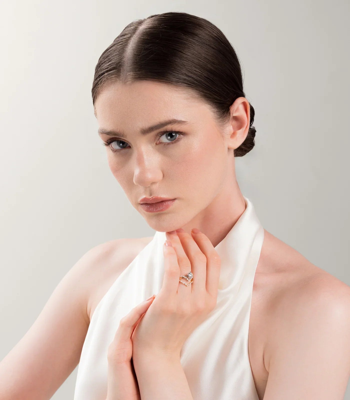 Woman wearing a "Keanis" bridal set, featuring a diamond engagement ring and a chevron band.