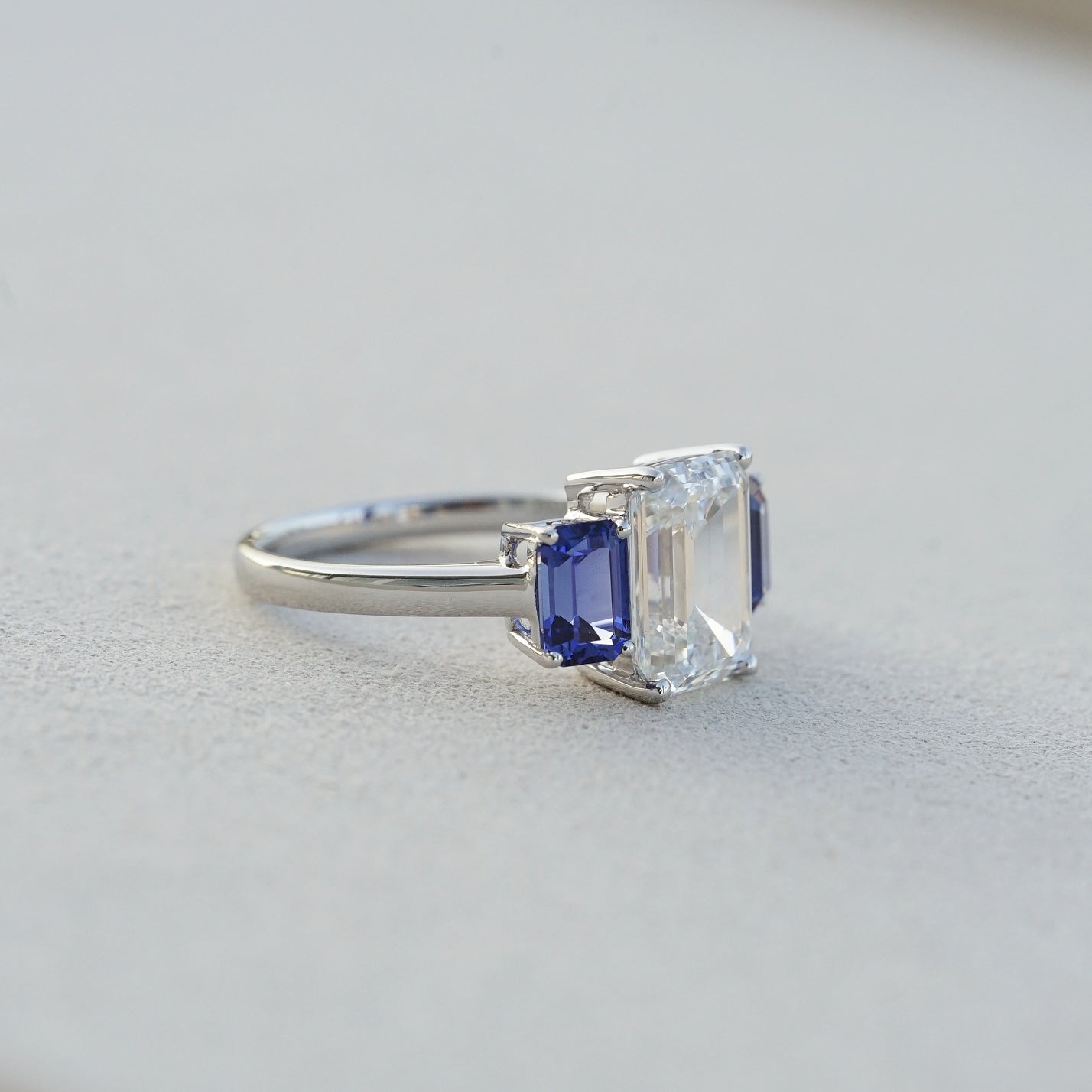 The Promise, IGI 3.09ct D VVS2 Emerald Cut Lab Diamond, PT950 Trilogy Ring with lab Sapphire Accents