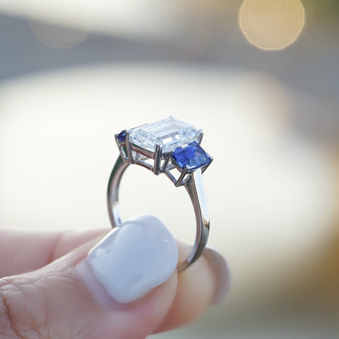 The Promise, IGI 3.09ct D VVS2 Emerald Cut Lab Diamond, PT950 Trilogy Ring with lab Sapphire Accents