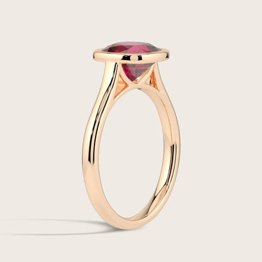 Cushion-cut lab-grown ruby solitaire ring in 18k rose gold, bezel setting.