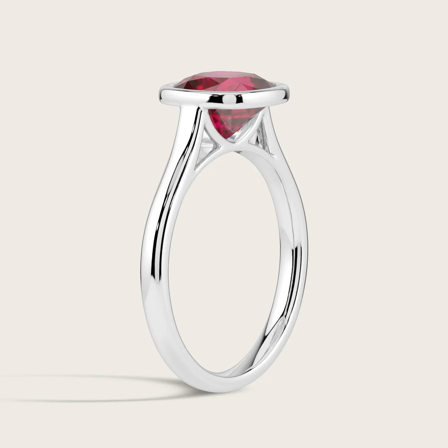 Lab-grown cushion ruby solitaire ring, bezel set in 18k white gold, side view. "R25201CU.
