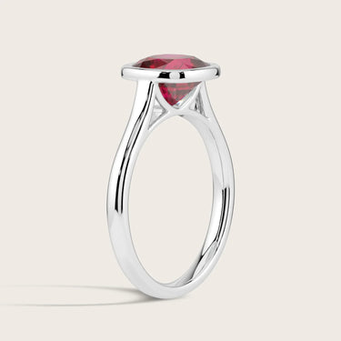 Lab-grown cushion ruby solitaire ring, bezel set in 18k white gold, side view. "R25201CU.