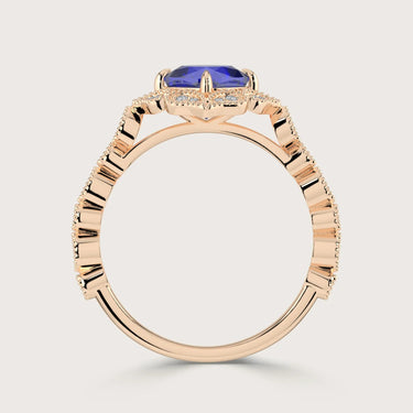 Side view of "lab-grown cushion sapphire" ring. Rose gold band, diamond halo, unique setting detail.