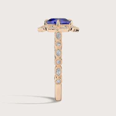Rose gold "cushion" cut lab-grown sapphire ring with diamond halo and band.