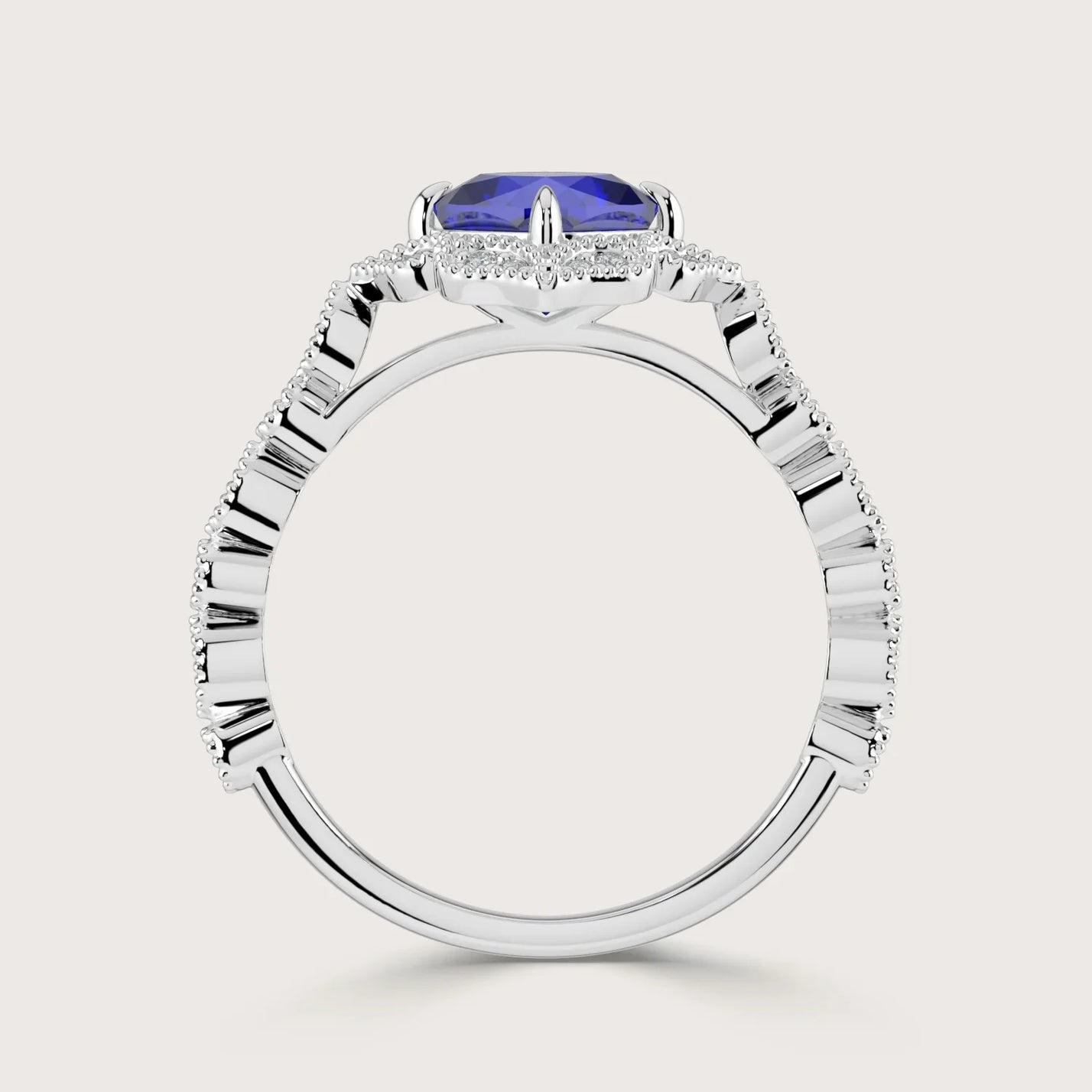 Side view of a "lab-grown cushion sapphire" ring with a diamond halo and band in 18k white gold.