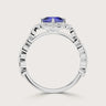 Side view of a "lab-grown cushion sapphire" ring with a diamond halo and band in 18k white gold.