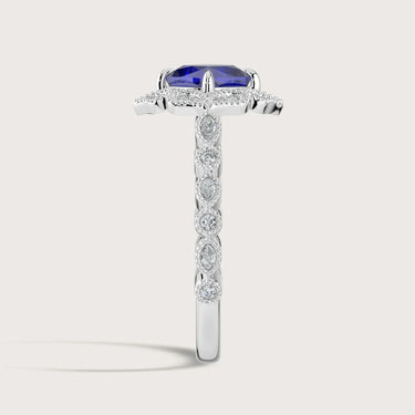 Lab-grown "cushion sapphire" ring. Halo setting with diamond band in 18k white gold. Side view.