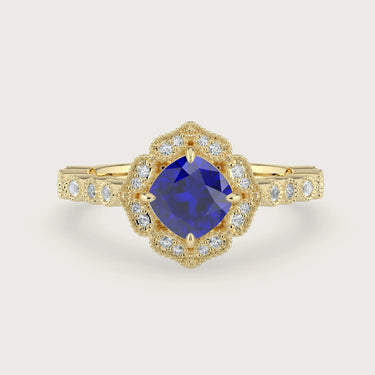 Lab-grown" cushion sapphire engagement ring. Diamond halo, 18k yellow gold band, vintage-inspired design.