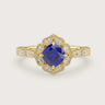 Lab-grown" cushion sapphire engagement ring. Diamond halo, 18k yellow gold band, vintage-inspired design.