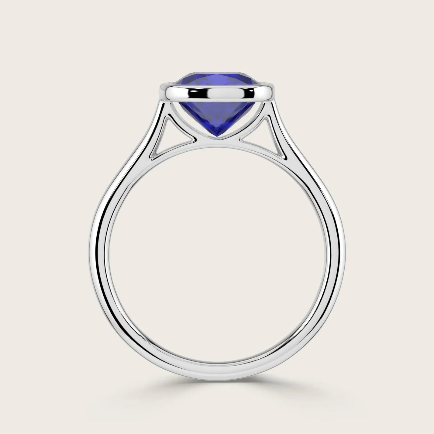 Lab-grown cushion sapphire solitaire ring. Bezel-set in 18k white gold, "R25201CU". Modern, elegant design.