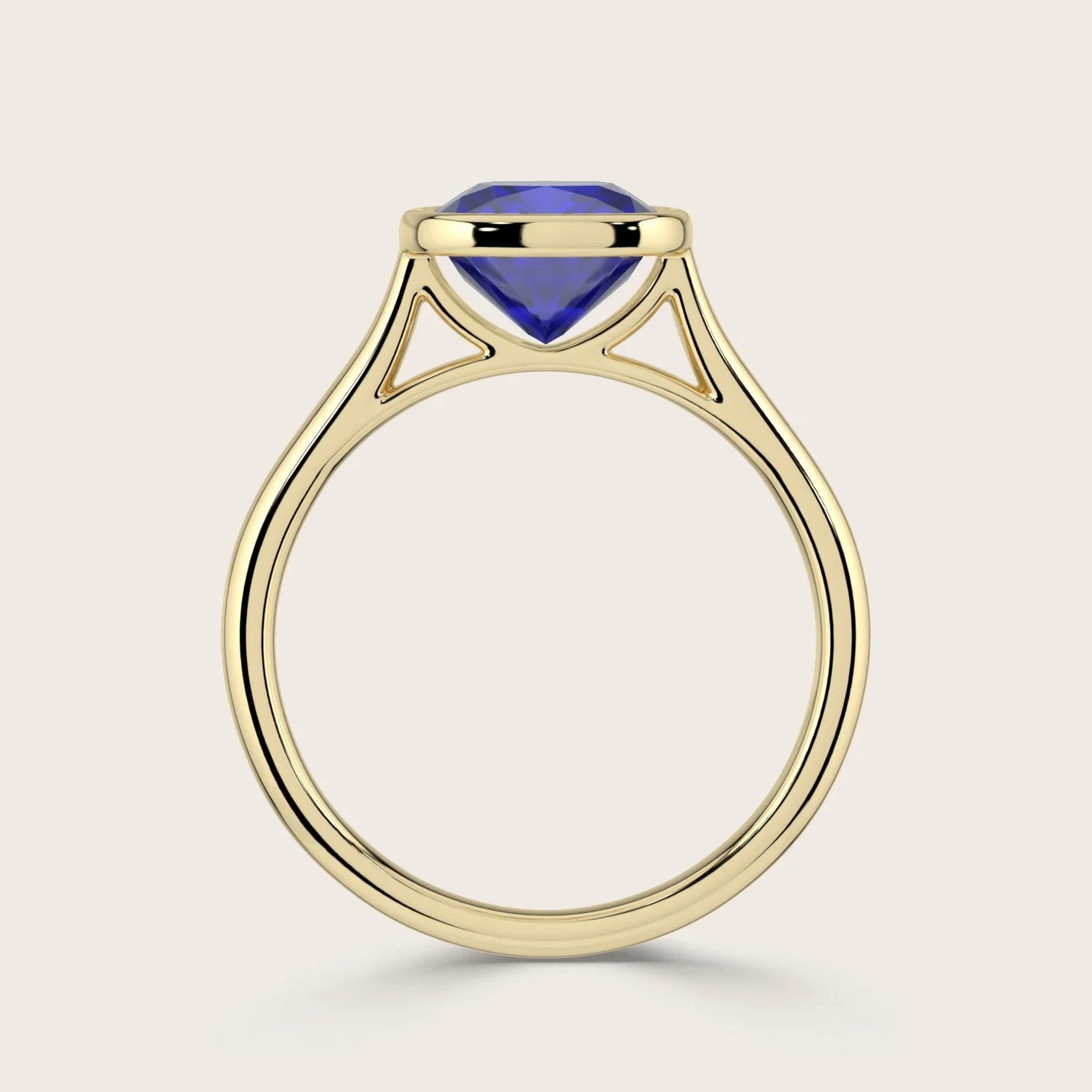 Side view of "lab-grown cushion sapphire" solitaire ring. Bezel set in 18k yellow gold.