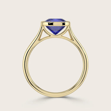 Side view of "lab-grown cushion sapphire" solitaire ring. Bezel set in 18k yellow gold.