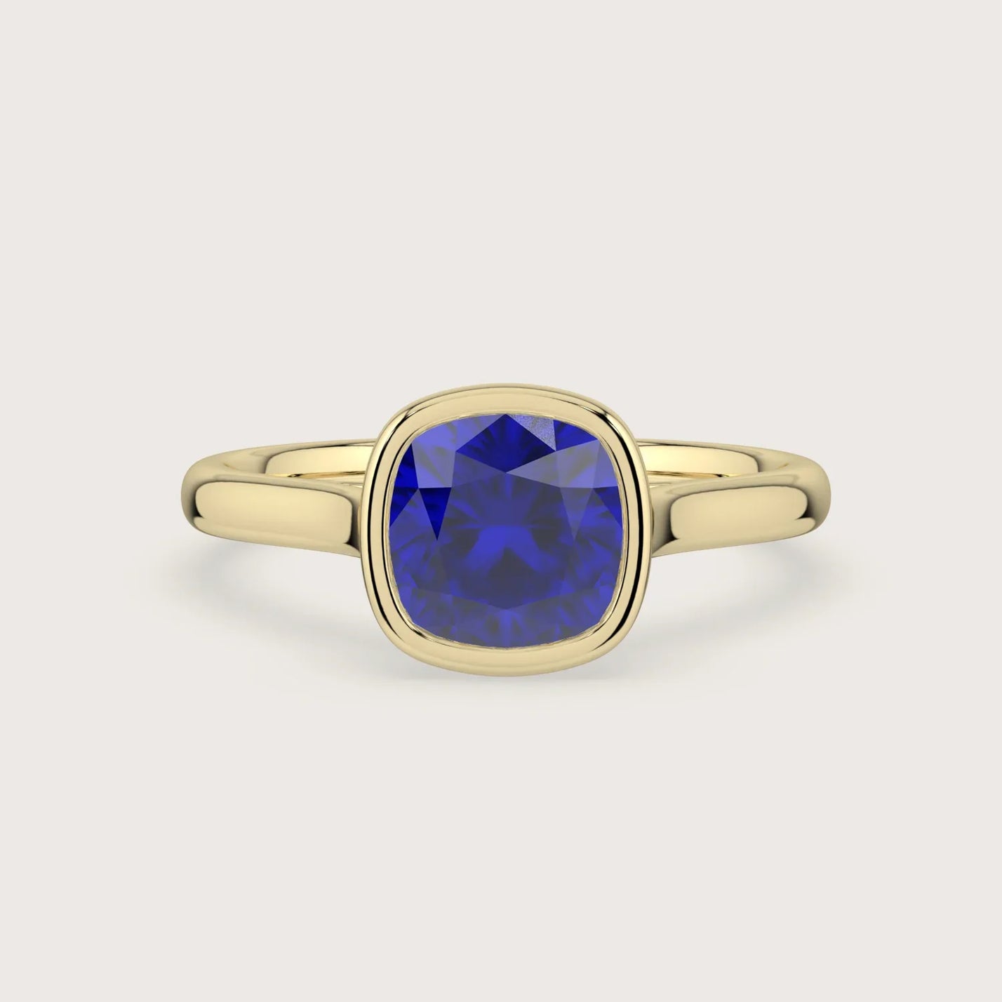 Lab-grown" cushion sapphire solitaire engagement ring in 18k yellow gold, bezel setting.