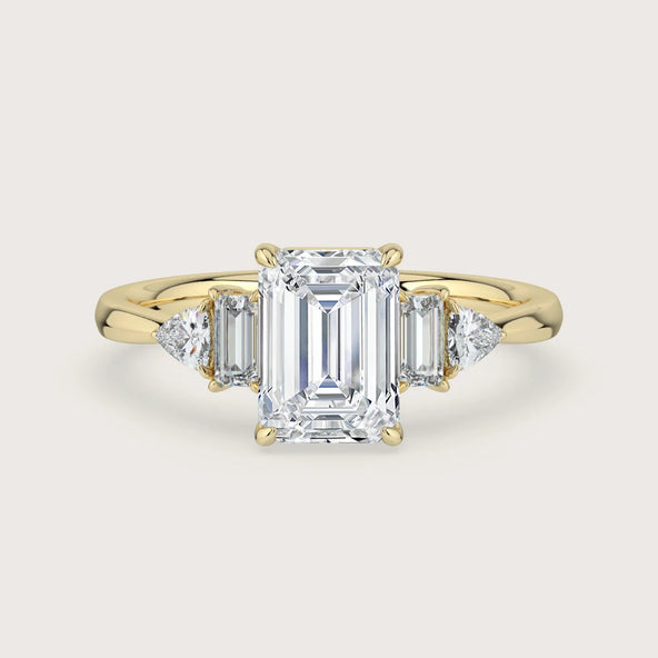 The Chapters" ring: Emerald cut lab-grown diamond with side baguettes and trillion accents in 18k yellow gold.