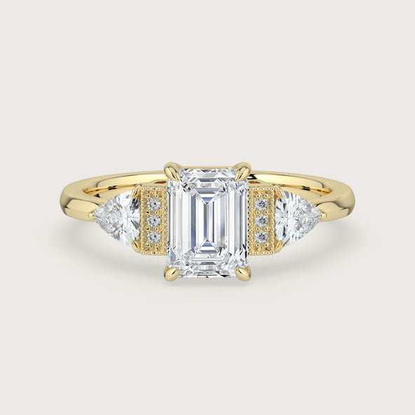 18k gold "The Chapters Heirloom" ring with emerald-cut lab-grown diamond and triangle side stones.