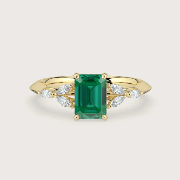 Lab-grown emerald engagement ring. "Vintage cluster" design in 18k yellow gold with leaf-shaped diamond accents.