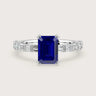 18k white gold engagement ring with sapphire "emerald" cut center stone and diamond band.