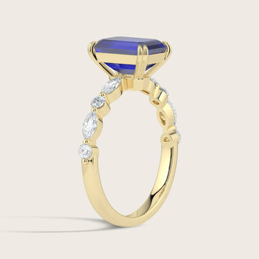 Gold ring with emerald-cut sapphire and diamond accents. "R24837EMA" band detail.