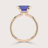 Lab-grown" sapphire ring. Emerald-cut blue stone in half-bezel setting with 18k rose gold band and small diamonds.