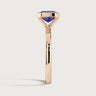 Side view of "R25201EM" lab-grown sapphire solitaire ring in 18k rose gold, half bezel setting.