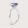 Lab-grown sapphire ring. Emerald cut blue gemstone in a 18k white gold solitaire half-bezel setting. Sparkly diamond accents.