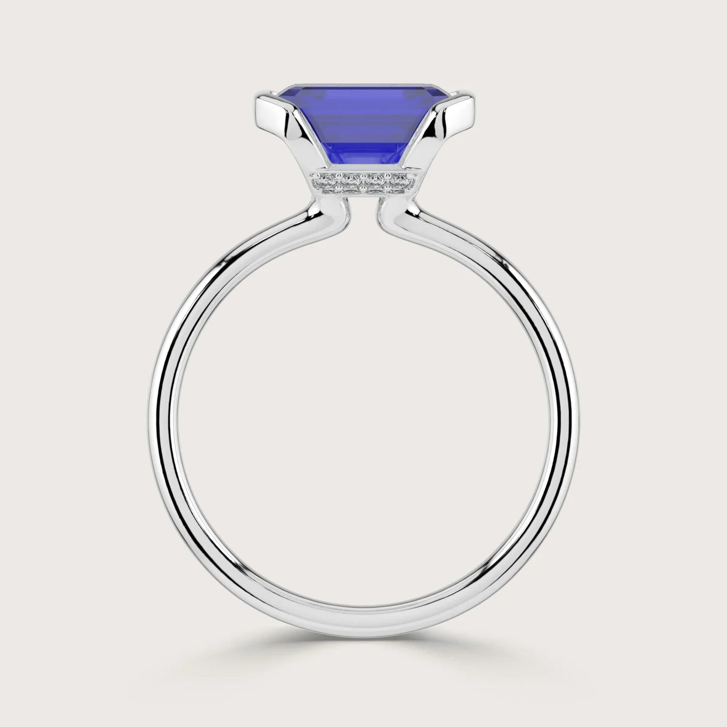 Close-up of a lab-grown sapphire solitaire ring with half bezel in 18k white gold.