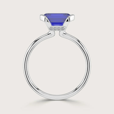 Close-up of a lab-grown sapphire solitaire ring with half bezel in 18k white gold.