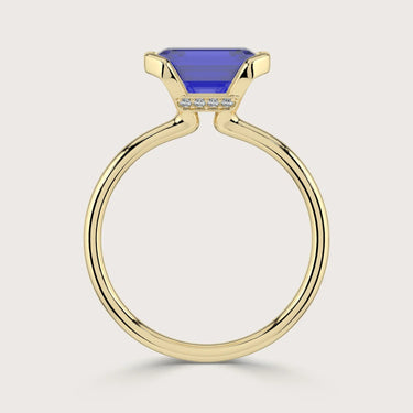 Lab-grown emerald-cut sapphire solitaire ring in 18k yellow gold with "half bezel" setting.