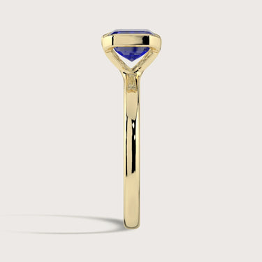 Lab-grown sapphire solitaire ring. Half bezel setting, 18k yellow gold band. "R25201EM" model.