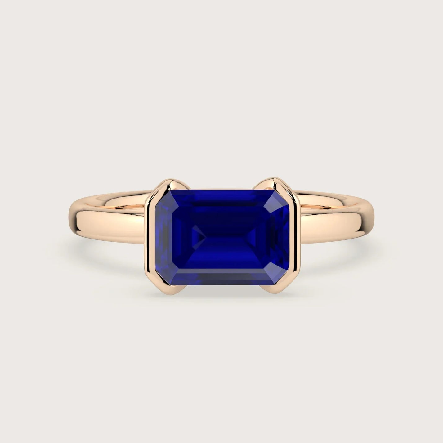 Rose gold "R25201EM" ring with vibrant, emerald-cut lab-grown sapphire in a half-bezel setting. Solitaire engagement ring.