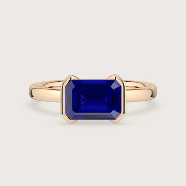 Rose gold "R25201EM" ring with vibrant, emerald-cut lab-grown sapphire in a half-bezel setting. Solitaire engagement ring.