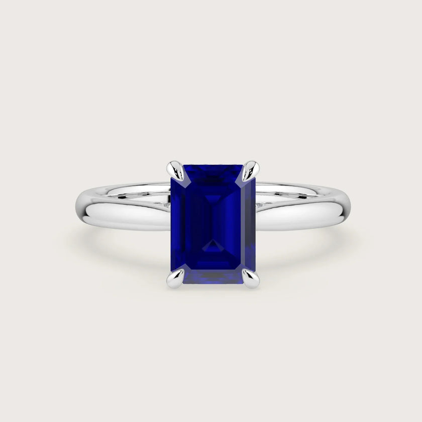 Lab-grown emerald-cut sapphire solitaire ring in 18k white gold with hidden halo. "R24819EMH" style.