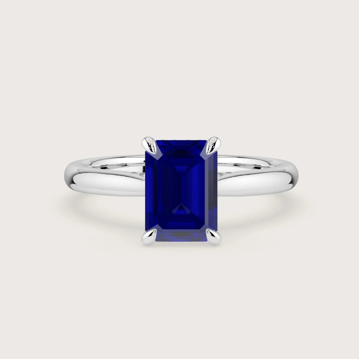 Lab-grown emerald-cut sapphire solitaire ring in 18k white gold with hidden halo. "R24819EMH" style.