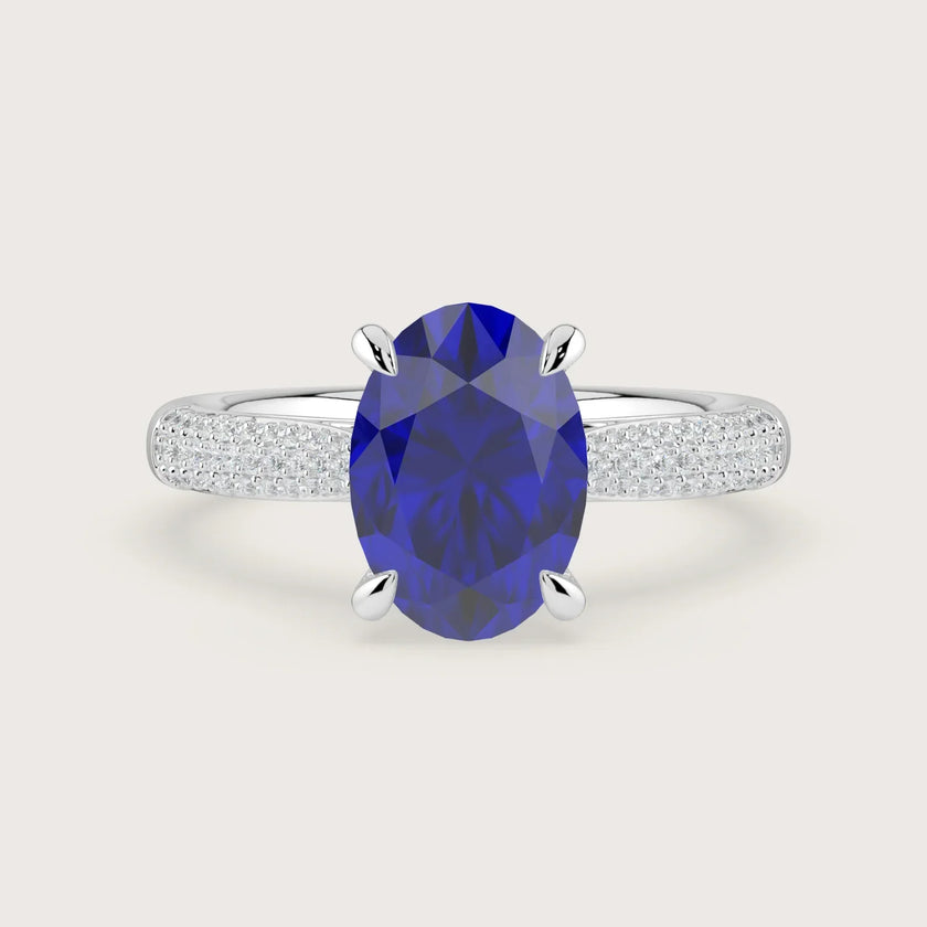 Oval lab-grown sapphire engagement ring with diamond band and "hidden halo" in 18k white gold.