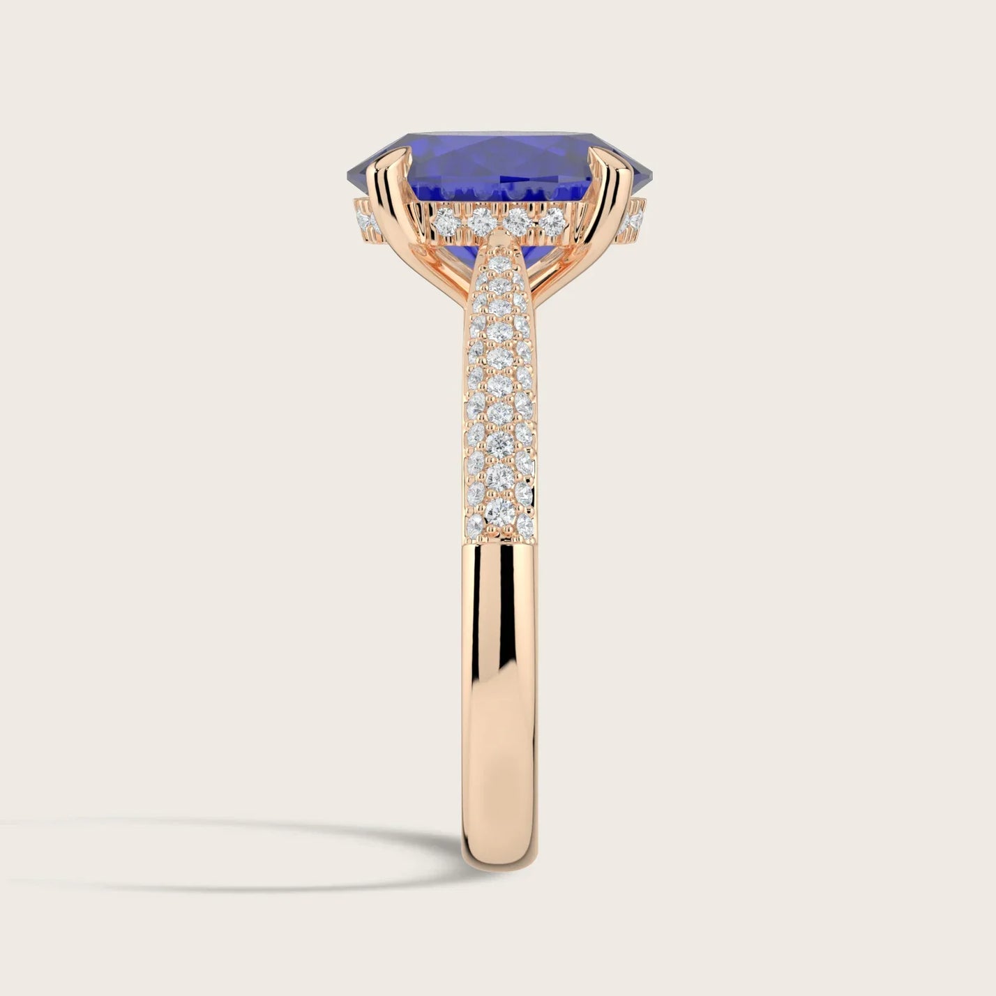 Rose gold ring with oval lab-grown sapphire, "hidden halo" setting, and diamond-paved band.
