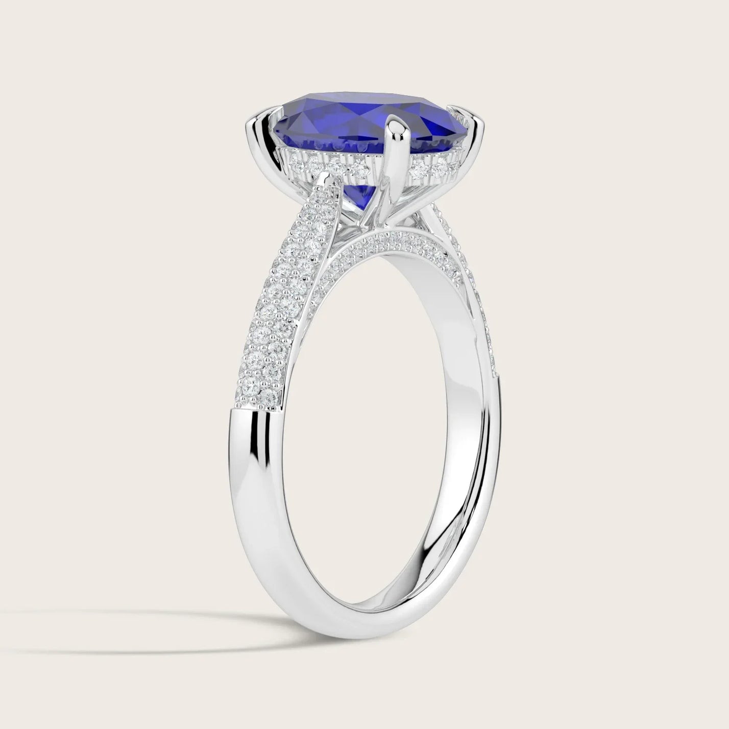 Lab-grown oval sapphire ring. "Hidden halo" diamond band in 18k white gold. Side view.
