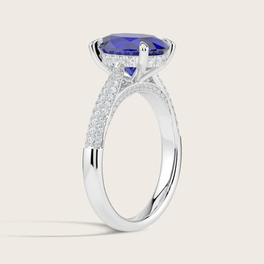 Lab-grown oval sapphire ring. "Hidden halo" diamond band in 18k white gold. Side view.