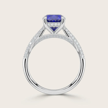 Lab-grown oval sapphire ring with a "hidden halo" and diamond band in 18k white gold.