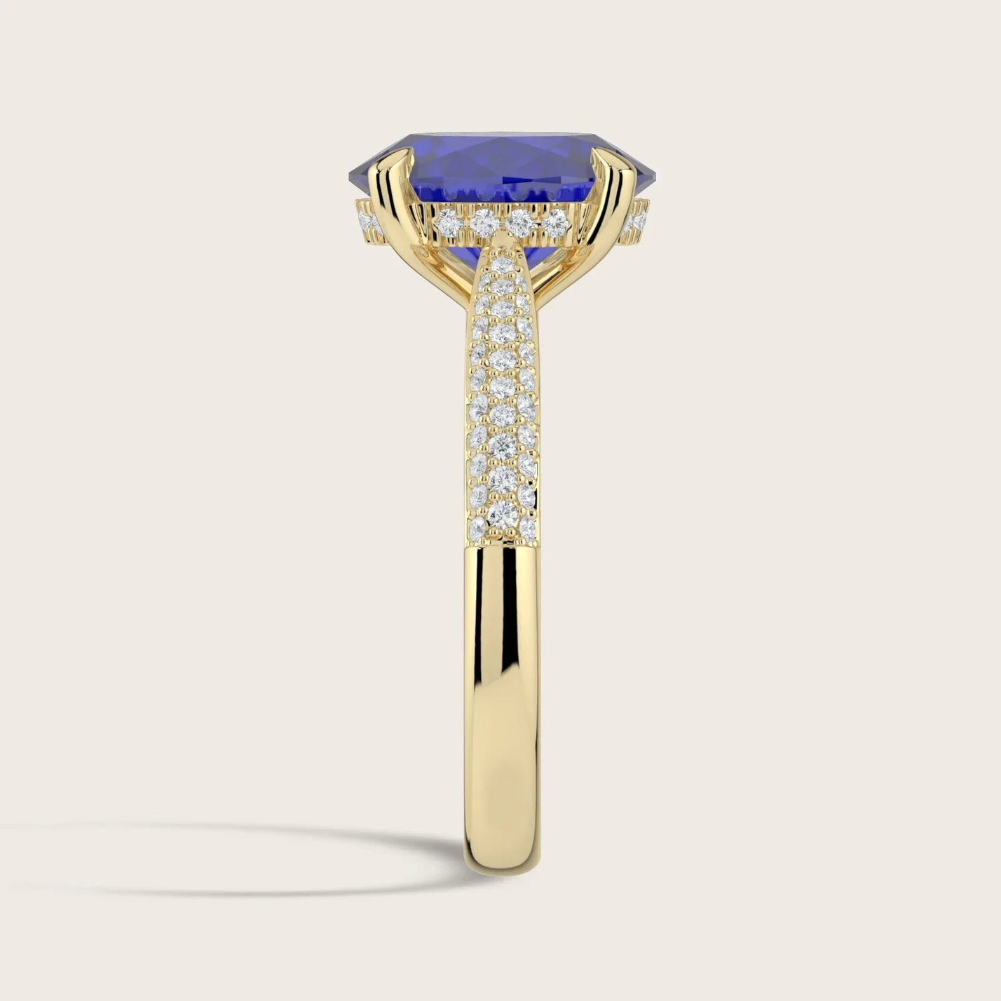 Lab-grown oval sapphire ring in 18k yellow gold with a "hidden halo" and diamond band detail.