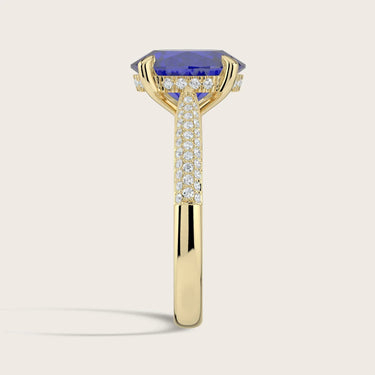 Lab-grown oval sapphire ring in 18k yellow gold with a "hidden halo" and diamond band detail.