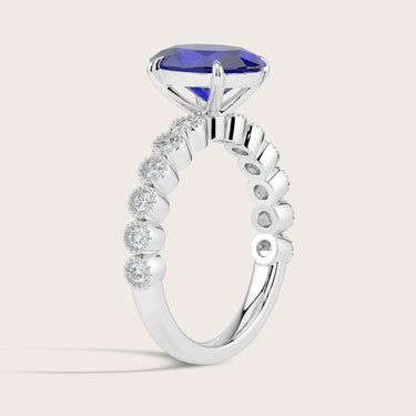 Lab-grown oval sapphire ring in 18k white gold with a milgrain vintage diamond band. Side view.