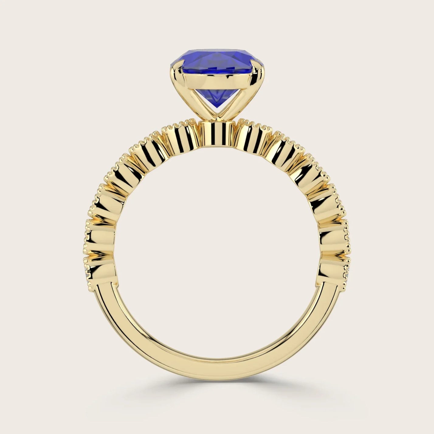 Close-up of an 18k yellow gold "milgrain" band ring with a lab-grown oval sapphire. Vintage style.