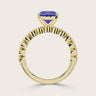 Close-up of an 18k yellow gold "milgrain" band ring with a lab-grown oval sapphire. Vintage style.