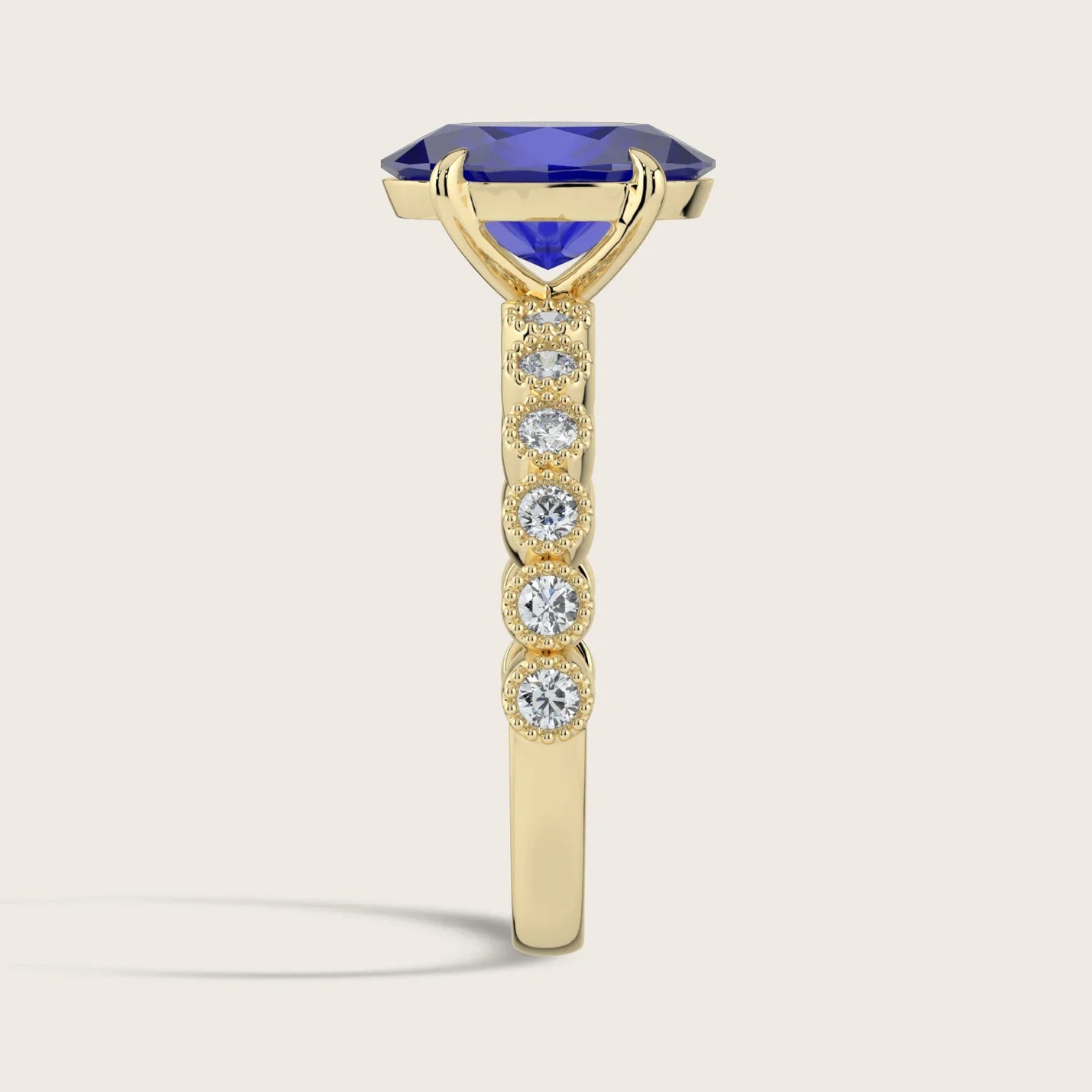 Side view of "R24822OVA" ring: Oval lab-grown sapphire in 18k yellow gold, milgrain vintage diamond band detail.