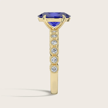Side view of "R24822OVA" ring: Oval lab-grown sapphire in 18k yellow gold, milgrain vintage diamond band detail.
