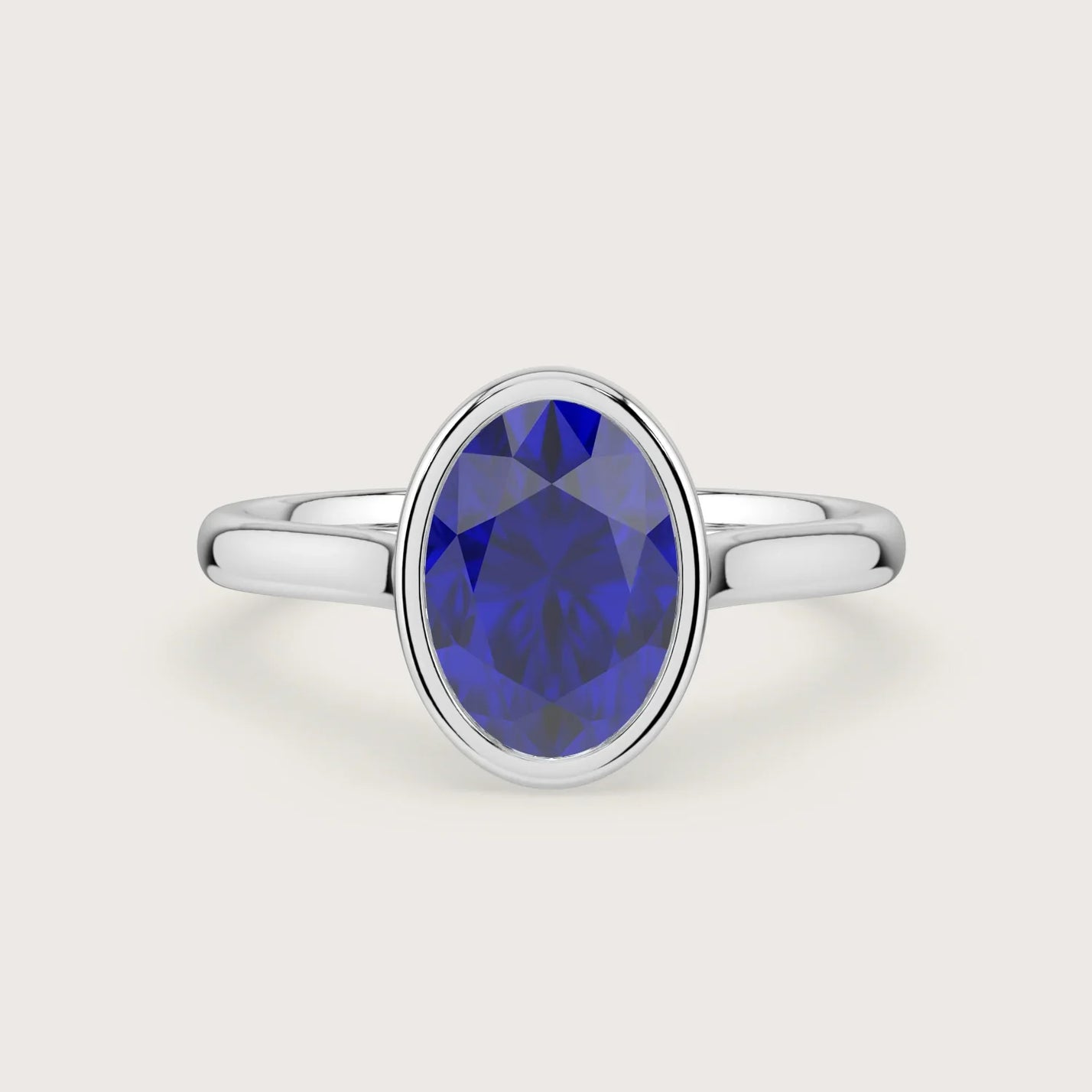 Oval lab-grown sapphire solitaire engagement ring in 18k white gold with bezel setting. "R25201OV.
