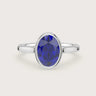 Oval lab-grown sapphire solitaire engagement ring in 18k white gold with bezel setting. "R25201OV.
