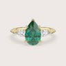Pear-shaped emerald trilogy engagement ring in 18k yellow gold. Lab-grown gemstone ring.