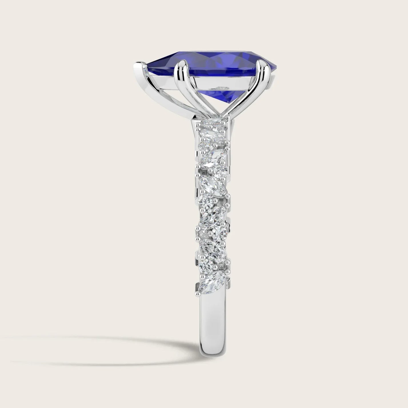 Side view of "lab-grown pear sapphire" ring with diamond band in 18k white gold.