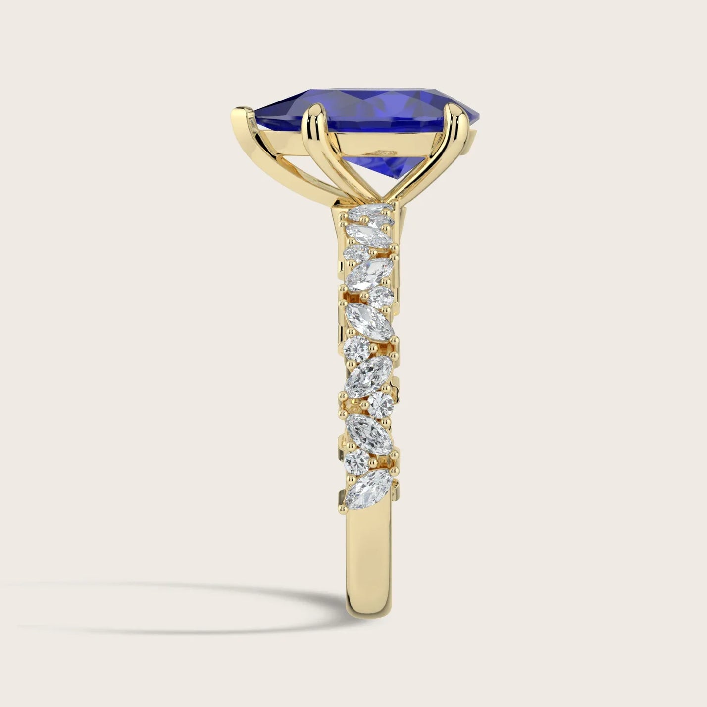 Lab-grown "pear" sapphire ring. 18k yellow gold band with diamond accents, side view.